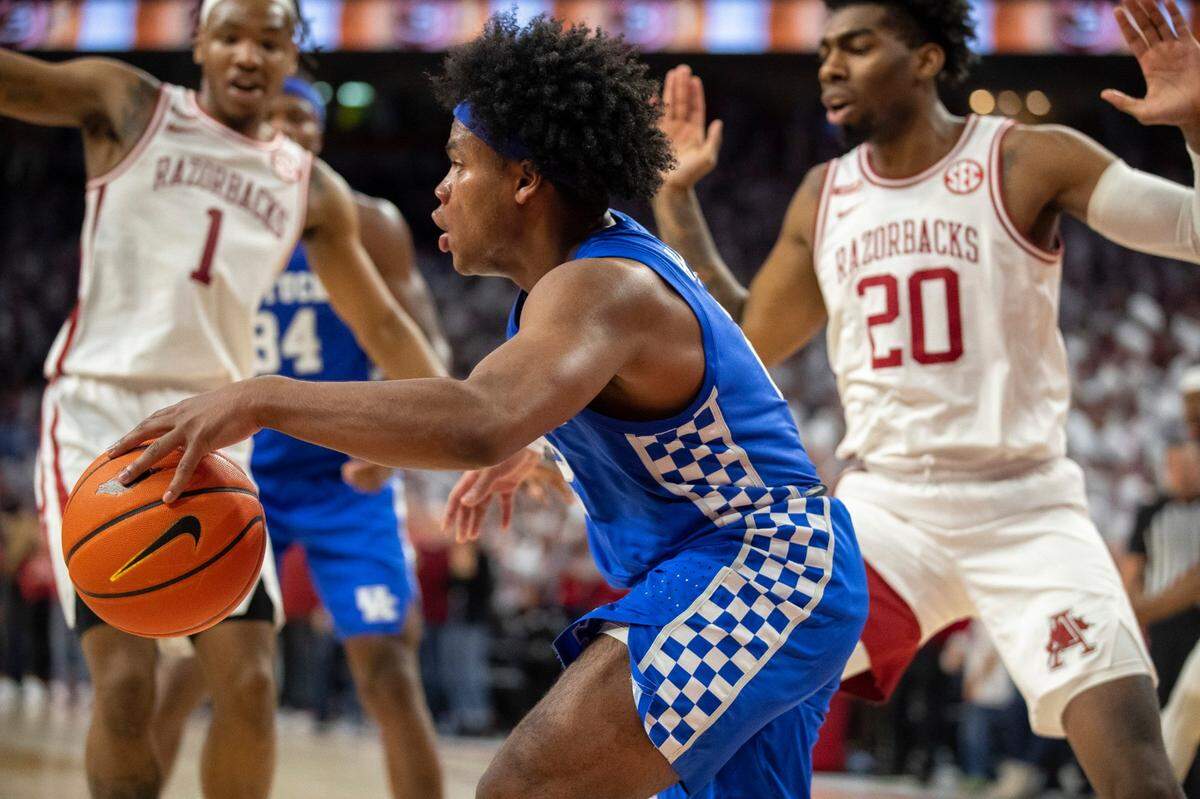 Kentucky’s Sahvir Wheeler, guarded by the Razorbacks’ JD Notae (1) and Kamani Johnson (20) on Saturday, scored 14 points and had five assists in his first game since missing two with an injury.