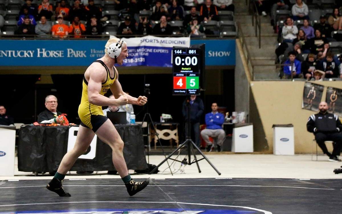 Woodford County’s Isaac Johns celebrates after winning his finals match in the 144-pound division at the boys/coed KHSAA State Wrestling Championships at the Kentucky Horse Park’s Alltech Arena on Friday.