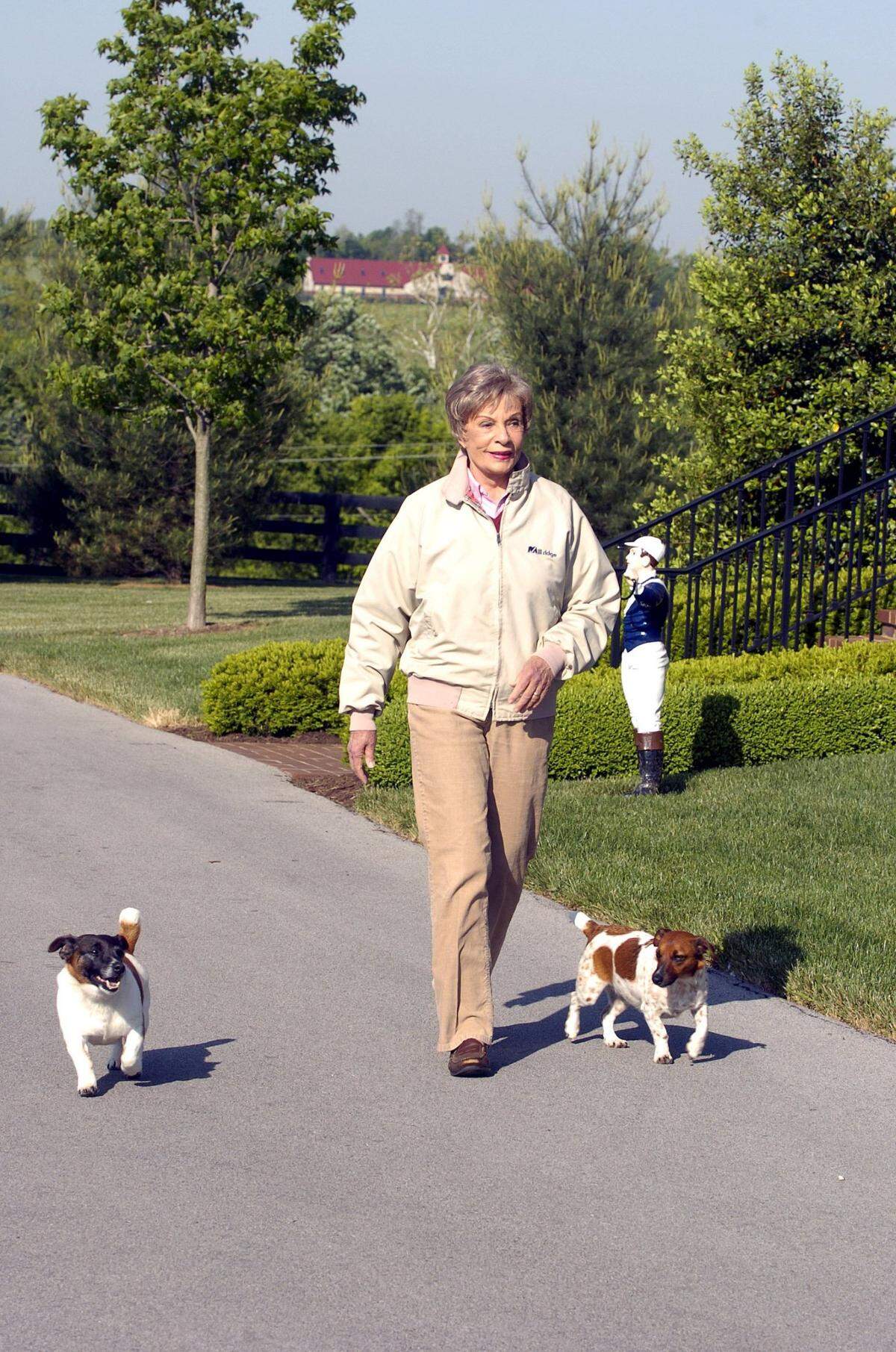 Alice Chandler, owner of Mill Ridge Farm, the birthplace of 2005 Kentucky Derby winner, Giacomo, Bowman’s Mill Road in Lexington, Kentucky walks with her dogs, Fast Eddie, at left and Millie (Jack Russells). May 17, 2005. FRANK ANDERSON/STAFF