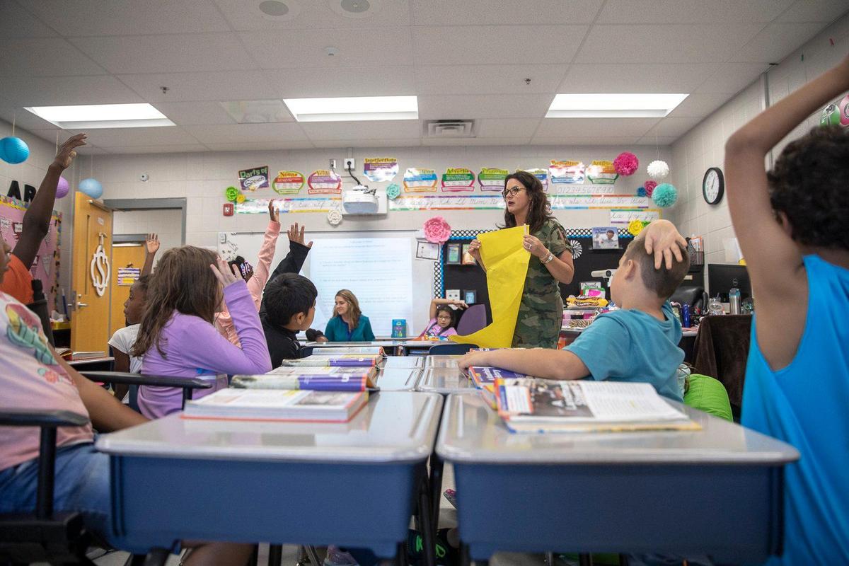 Teacher Stephanie Scott works with students in her third grade class at Squires Elementary School in Lexington on Monday.