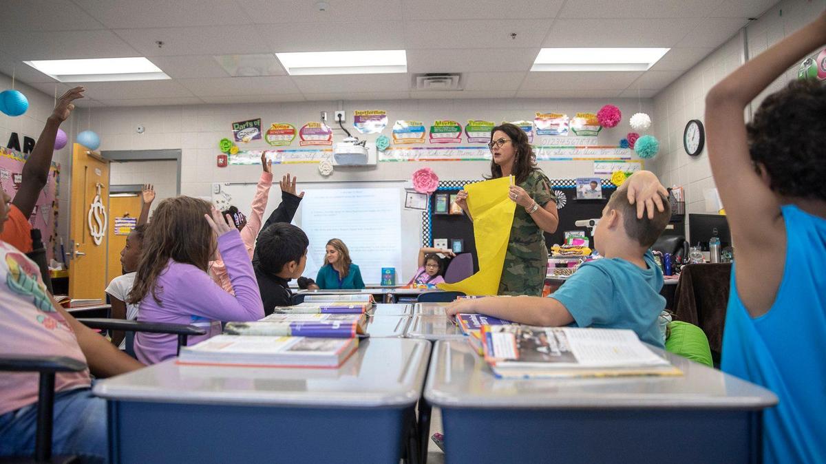 Teacher Stephanie Scott works with students in her third grade class at Squires Elementary School in Lexington on Monday.