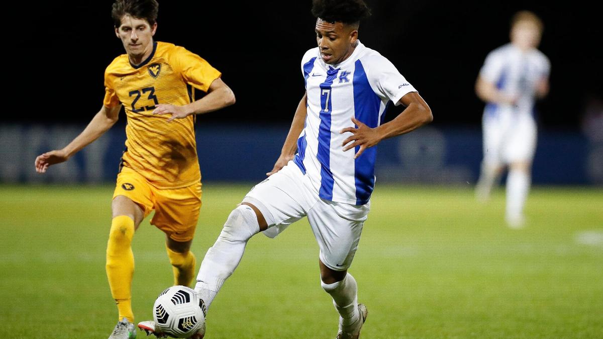 Kentucky forward Daniel Evans (7) kicked the ball past West Virginia midfielder Ryan Baer (23) during a match in Lexington on Oct. 19. UK, which finished the season with 14 wins from 19 games played, automatically qualified for the NCAA Tournament by winning the Conference USA Tournament this weekend.