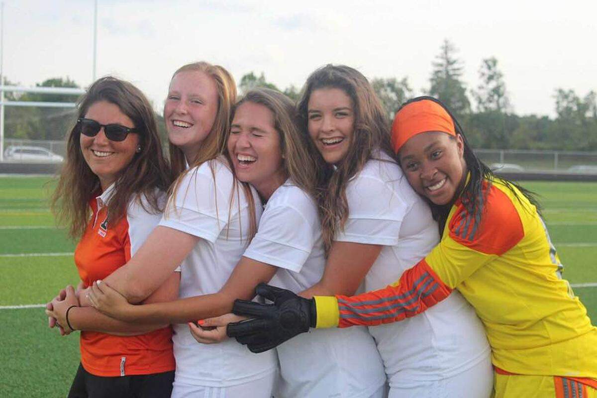 Frederick Douglass girls’ soccer coach Megan Adkins got some love from some of her players on team photo day recently with hugs, from left, Emily Coker, Lindsey Hager, Ellie Kiper and Maliya Crump.