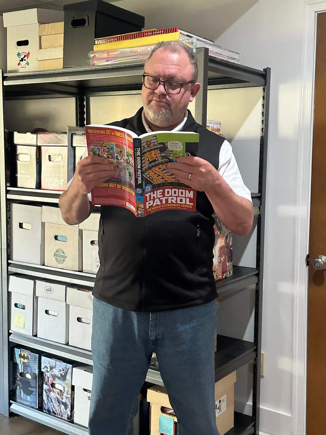 Bill Bissett was photographed with with a portion of his scaled-down comic book collection while reading a reprinted collection of his favorite comic book, “The Doom Patrol.” The longtime collector will offer tips and advice at this weekend’s LexCon on how to downsize your collection.