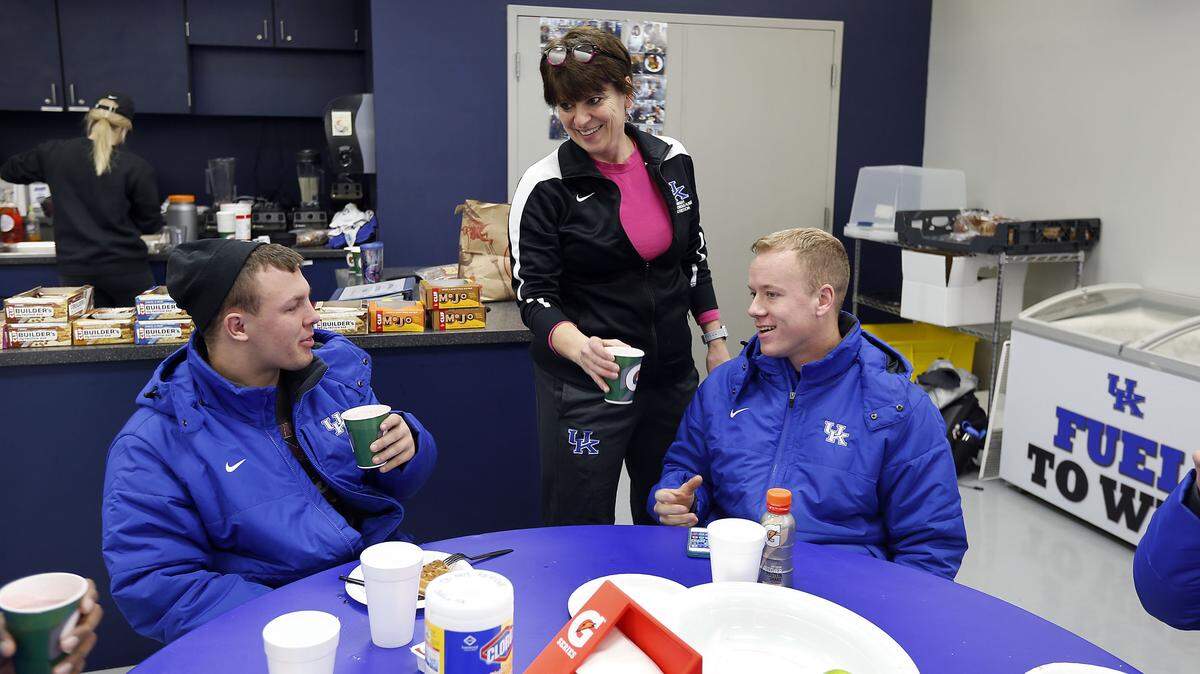 Monica Fowler handed smoothies to players Will Tom Collins, left, and Grant Aumiller at Kentucky's Nutter Football Training Facility. The UK football dietitian and nutritionist, many affectionately call Fowler "Miss Monica" or "Mama Fowler."           