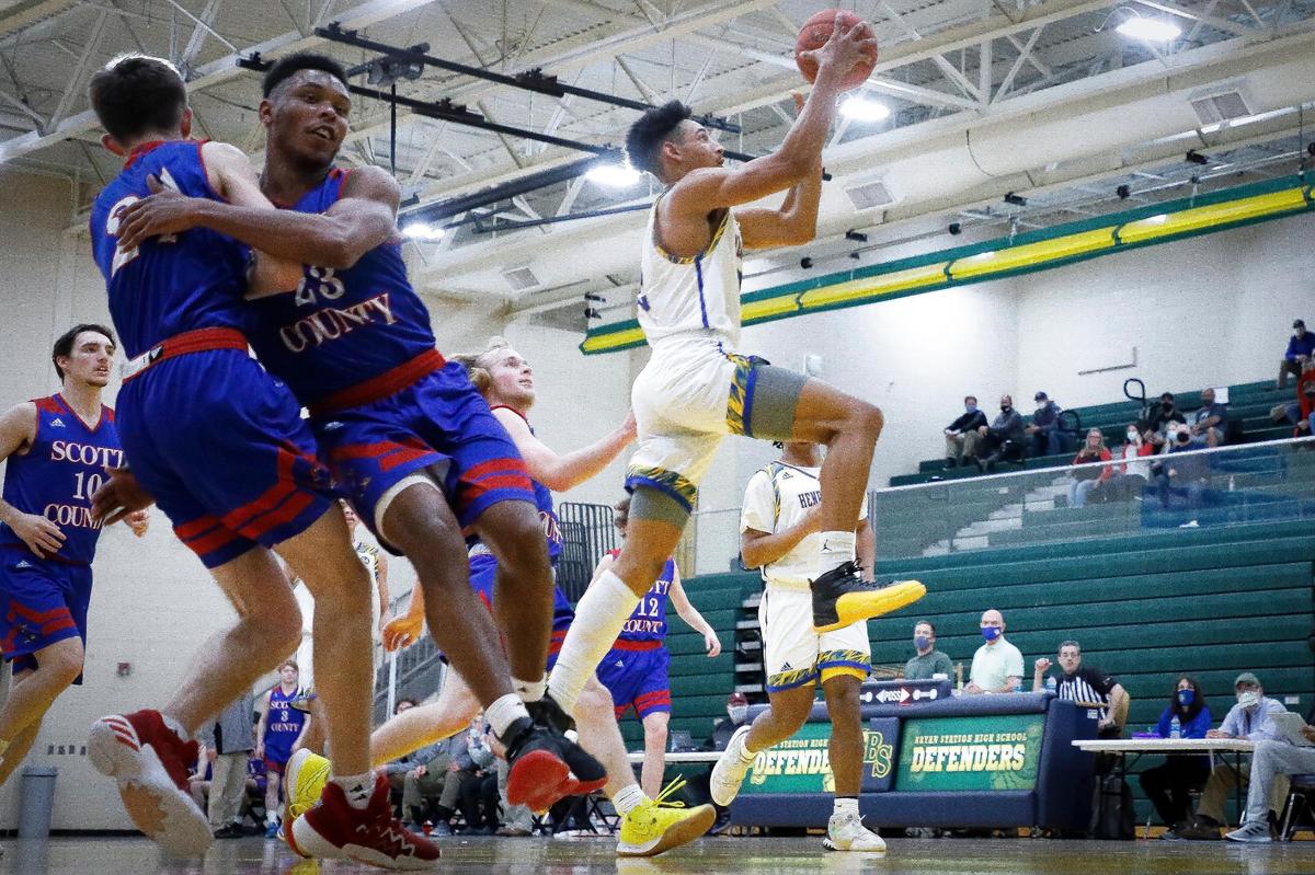 Henry Clay’s Darik Holman (22) shot over Scott County defenders during their 42nd District semifinal at Bryan Station High School on Wednesday night.