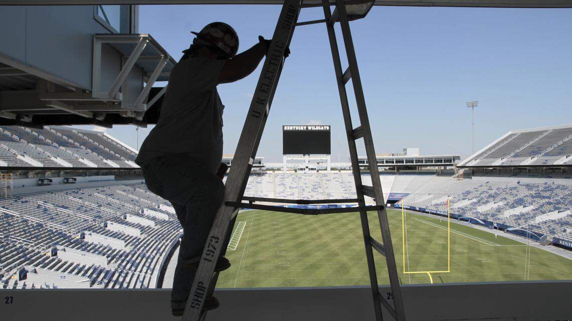 Tommy Posey, Derby City Signs, used a ladder while cutting entry holes for brackets that hold the ribbon panels during construction of the new scoreboards and the electronic ribbons on Monday, Aug. 29, 2011 at Commonwealth Stadium in Lexington, Ky.  The graphics ribbons are attached to the upper deck and under the scoreboards and thus ring the stadium. For an article advancing changes that UK football fans may want to know about, we need to shoot work on the vast new scoreboard and its "ribbons" around the stadium.   Photo by David Perry | Staff
