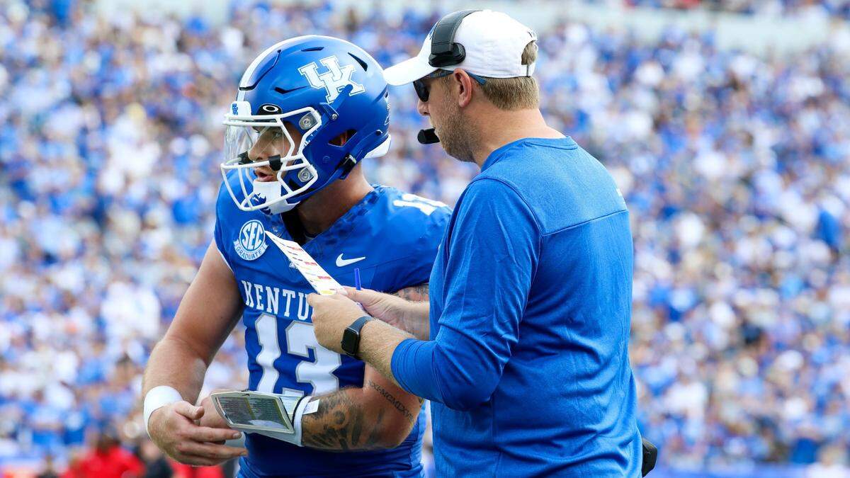 Kentucky offensive coordinator Liam Coen, right, talked with quarterback Devin Leary (13) during UK’s 44-14 victory over Ball State last week. Due to various circumstances, the Wildcats’ offense ran only 51 plays from scrimmage in the game.