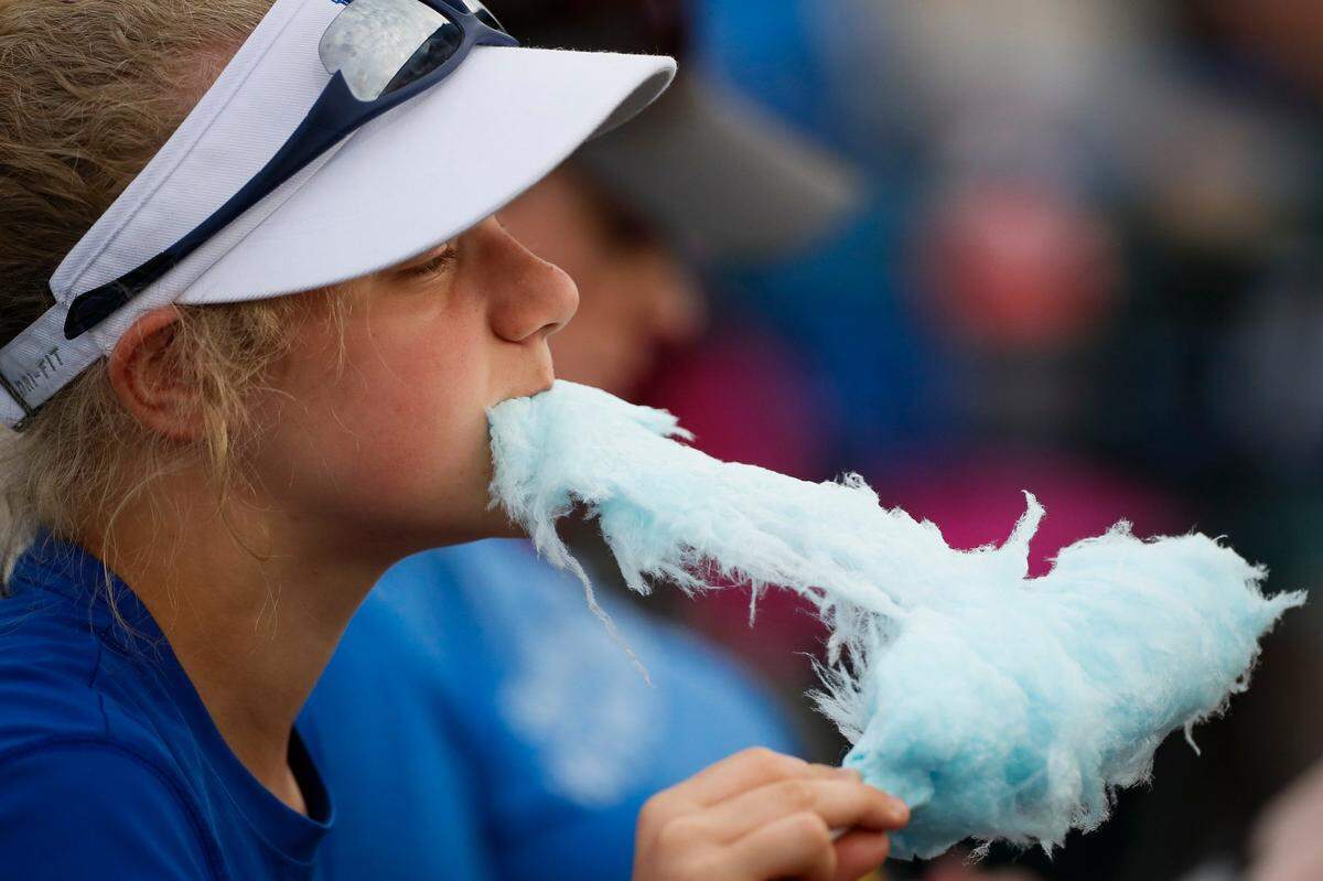 Holly Marshall, 13, of Lexington, Ky., eats cotton candy in the stands during the NCAA Lexington Regionals between the Kentucky Wildcats and the Northwestern Wildcats at John Cropp Stadium in Lexington, Ky., Saturday, May 22, 2021. Kentucky beat Northwestern 7-2.