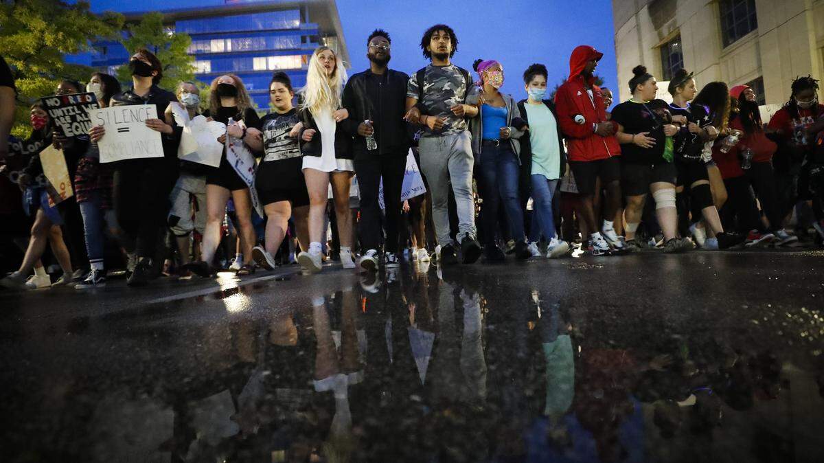 Demonstrators lock arms while marching along East Main Street during the seventh night of protests in downtown Lexington on Thursday. The protests come amid a nationwide outcry over the deaths of George Floyd in Minneapolis and Breonna Taylor in Louisville.