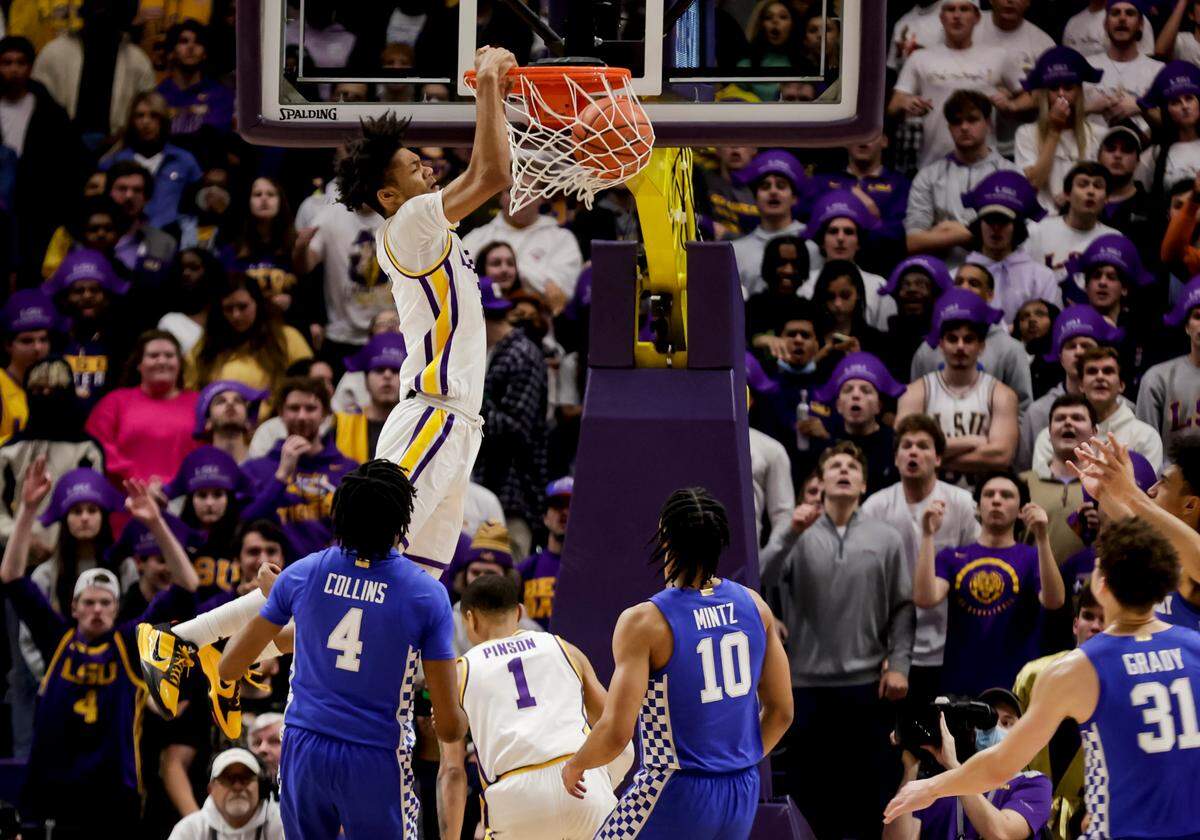 LSU’s Alex Fudge (3) dunks over Kentucky’s Daimion Collins (4) and Davion Mintz (10) on Tuesday night. The Tigers improved to 13-1. The Wildcats fell to 11-3.