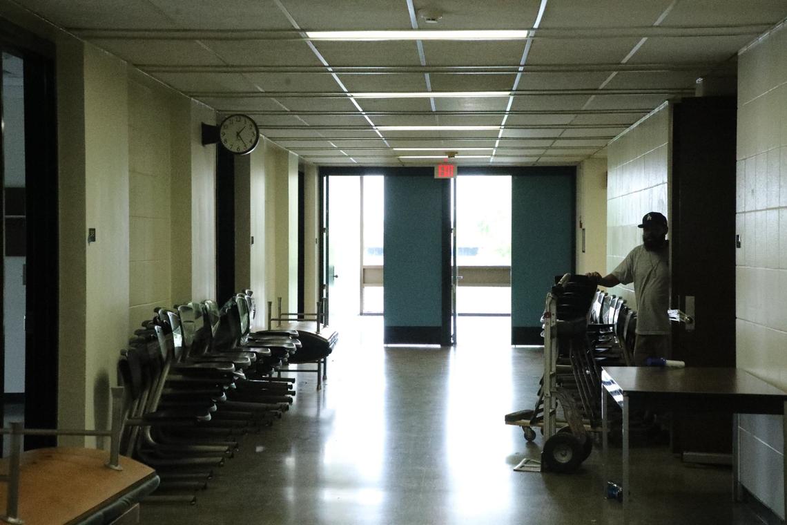 A crew member moves chairs from a vacant classroom at White Hall at the University of Kentucky prior to major renovations on June 5, 2024, in Lexington, Ky.