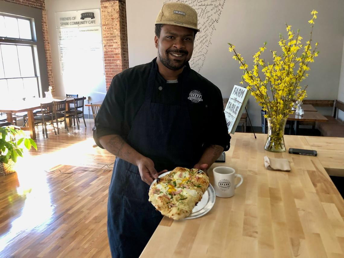 Chef Isaiah Screetch of Spark Community Cafe in Versailles, holding the Eggs Benedict Pizza served on Sunday at brunch, is a semifinalist for a James Beard Award.