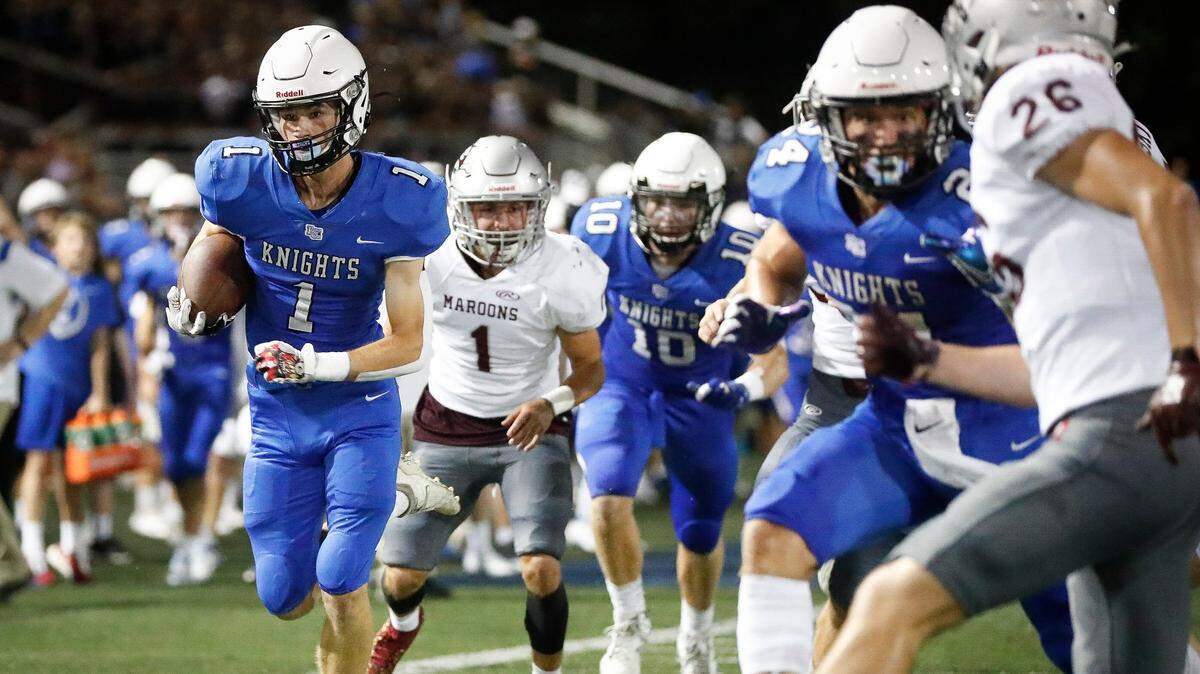 Lexington Catholic’s Max DeGraff (1) runs the ball around Pulaski County defenders during the Traditional Bank Bluegrass Bowl at Lexington Catholic High School in Lexington, Ky., Friday, Aug. 27, 2021. Lexington Catholic Beat Pulaski County 38-36 on a DeGraff 47-yard field goal.