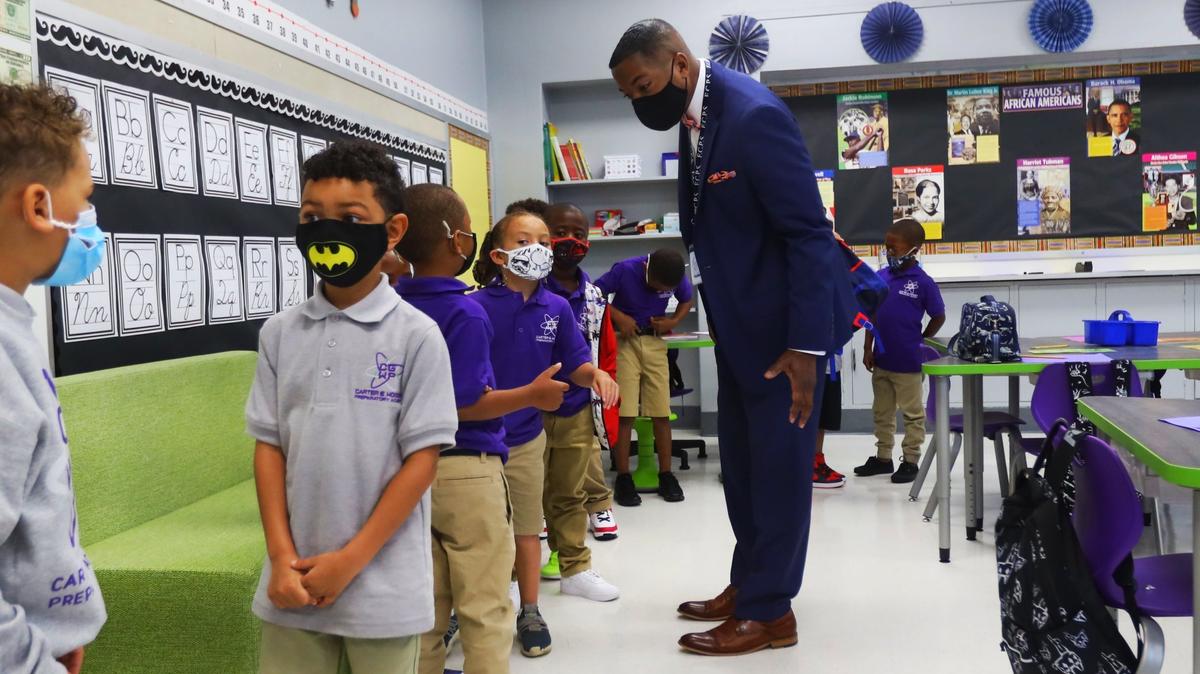 Superintendent Demetrus Liggins greets first grade students on their first day of school, August 11, 2021, at the new Carter G Woodson Preparatory academy on East Sixth St.
