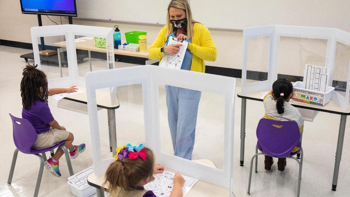 Jennifer Lopez gives instruction to students at their desks working on an exercises behind plastic desk shields in the kindergarten classroom at the Rise Stem Academy for Girls in Lexington, Ky., Monday, October 19, 2020.