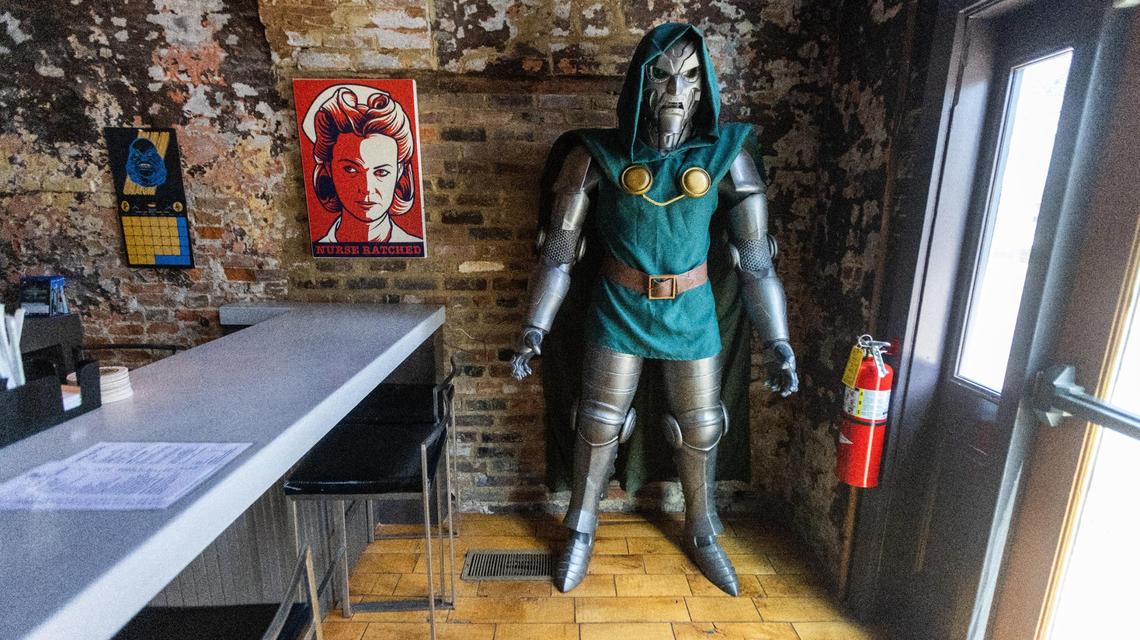 Left to right, a Creature From the Black Lagoon calendar, a poster of Nurse Rached from “One Flew Over the Cuckoo’s Nest,” and a life size replica of Marvel comic villain Dr. Doom are along a wall next to the bar within Villainous table-top gaming pub on Jefferson Street. August 24, 2022.