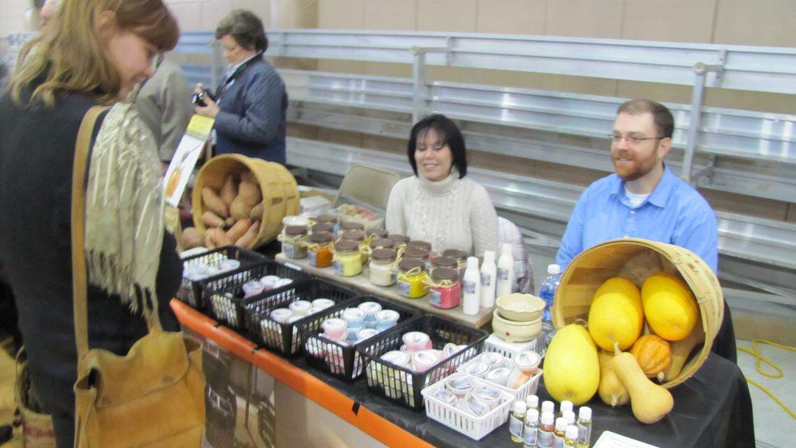 Tina and Tony Edwards, seated, of Breathitt County were among the vendors on hand during Monday's announcement in Hindman of a new marketing effort for Eastern Kentucky farm products. The couple grow vegetables, and she makes soy candles.  