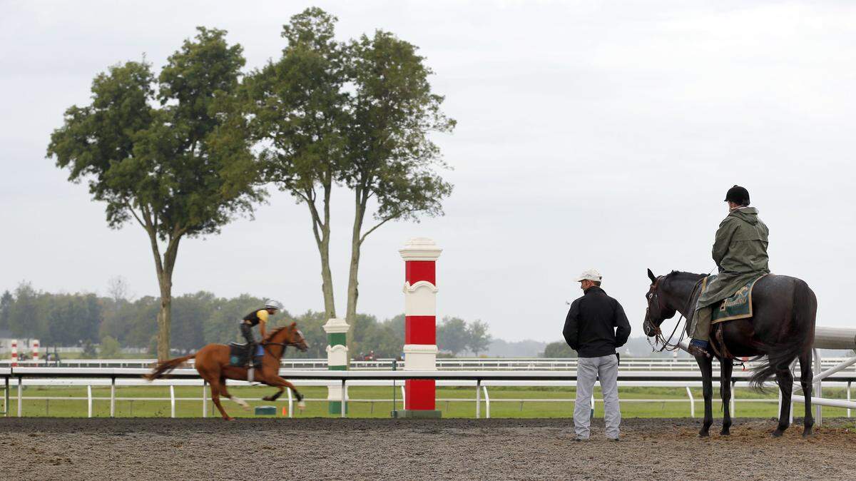 Assistant trainer Donal McCabe and Keeneland outrider Gene Vosler observed an early-morning work ahead of Keene-land's Fall Meet.  