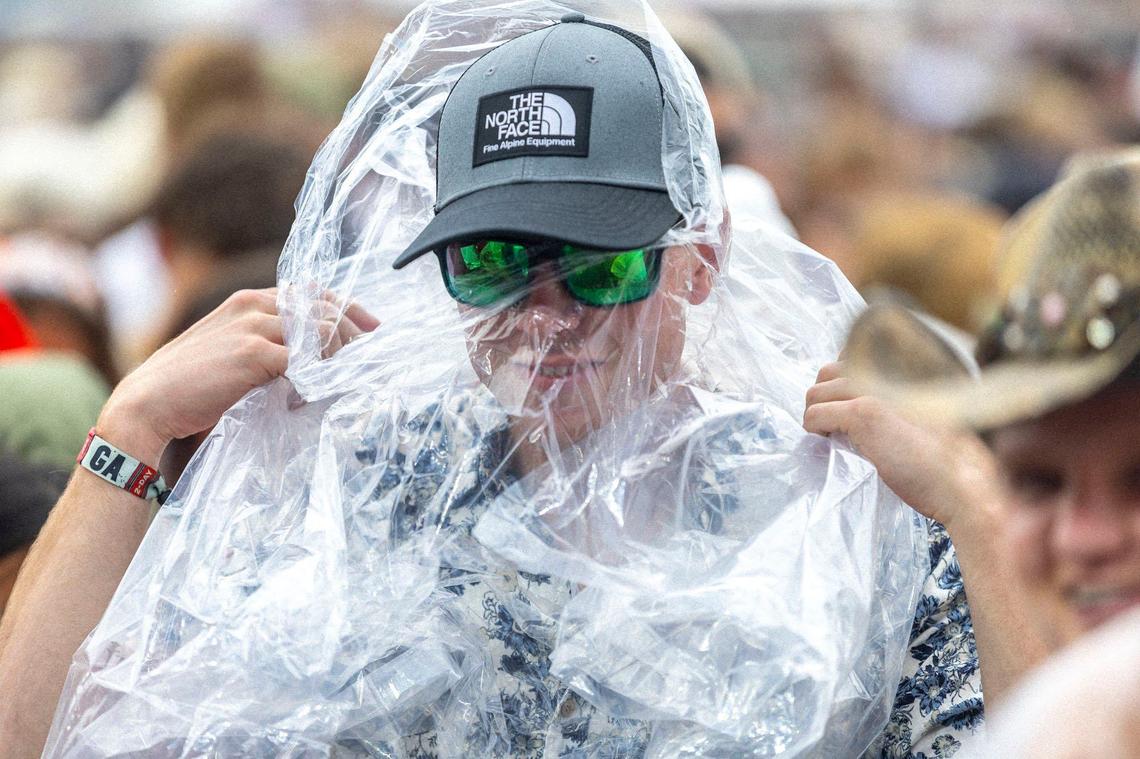 Carson Lonning, of Iowas, puts on a poncho before Flatland Cavalry performs during the Railbird Music Festival at at Red Mile in Lexington, Ky., on Saturday, June 1, 2024.