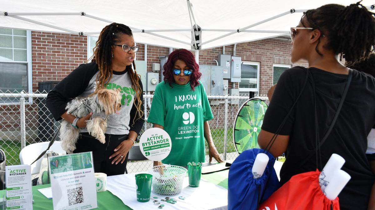From left, Dawn Runyon and Gloria Collins speak to Keana Brown about Green Dot during Winburn Public Safety Day on Wednesday, June 28, 2023 at the Community Action Council Center in Lexington, Ky.