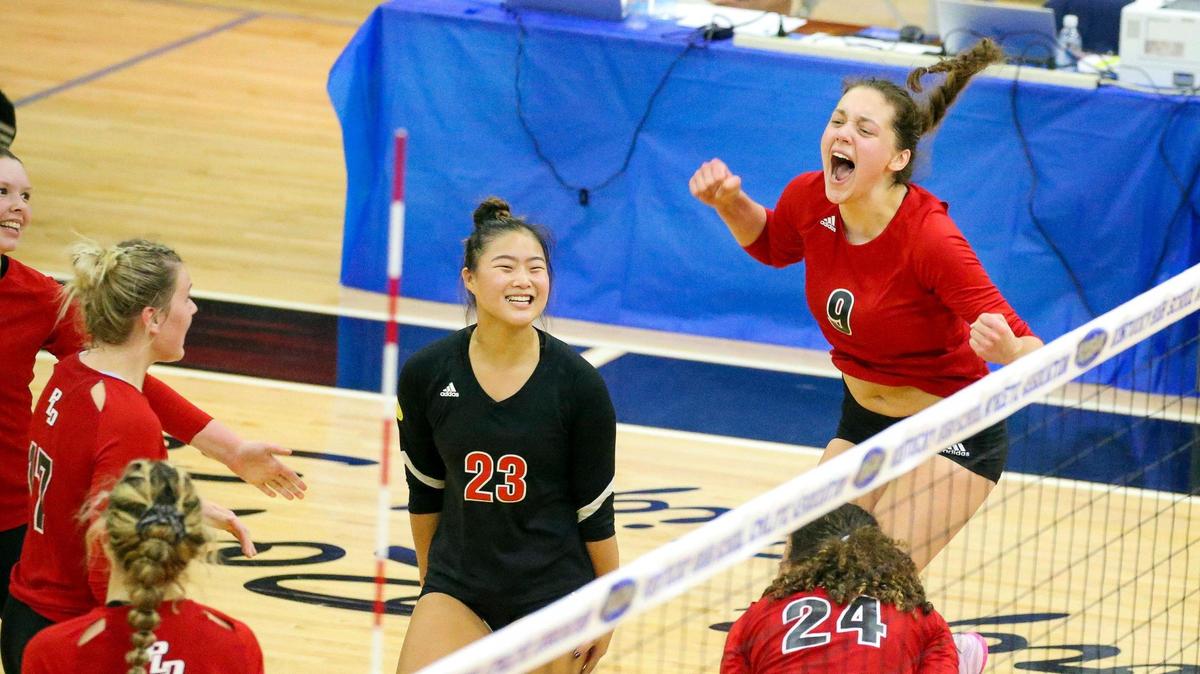 Paul Laurence Dunbar’s Ava Jackson (9) and Mia Telechbush (23) celebrate after a point during Friday’s state volleyball semifinals.