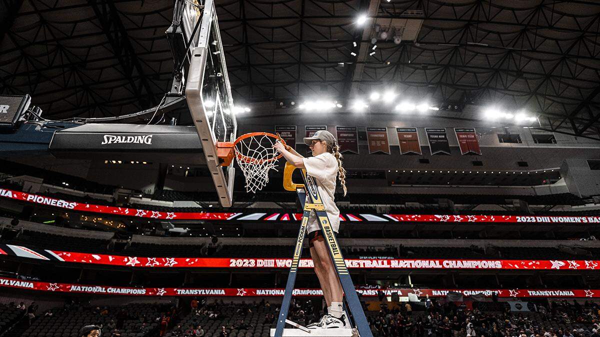 Transylvania’s Madison Kellione cuts down part of the net following the NCAA Division III Tournament championship game on Saturday in Dallas.