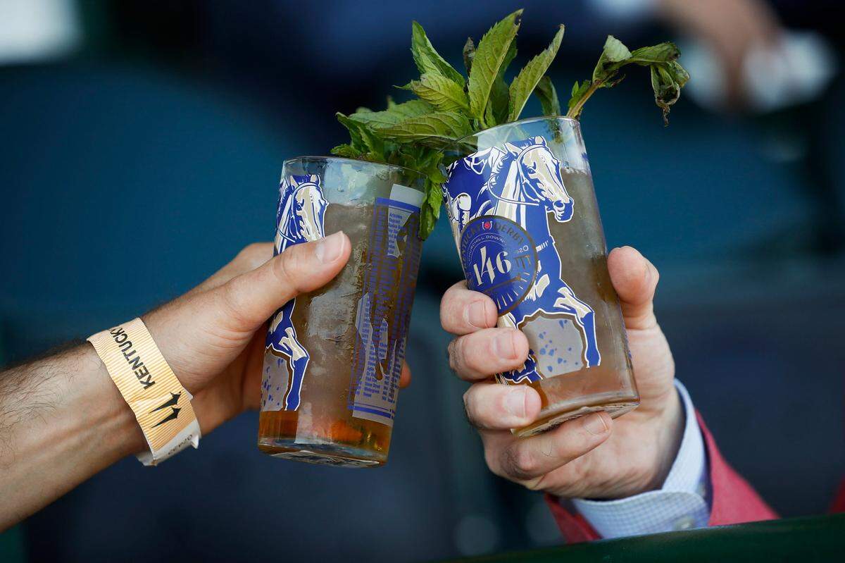 Two mint juleps are clinked in the stands before the 146th running of the Kentucky Derby at Churchill Downs in Louisville, Ky., Saturday, Sept. 5, 2020.