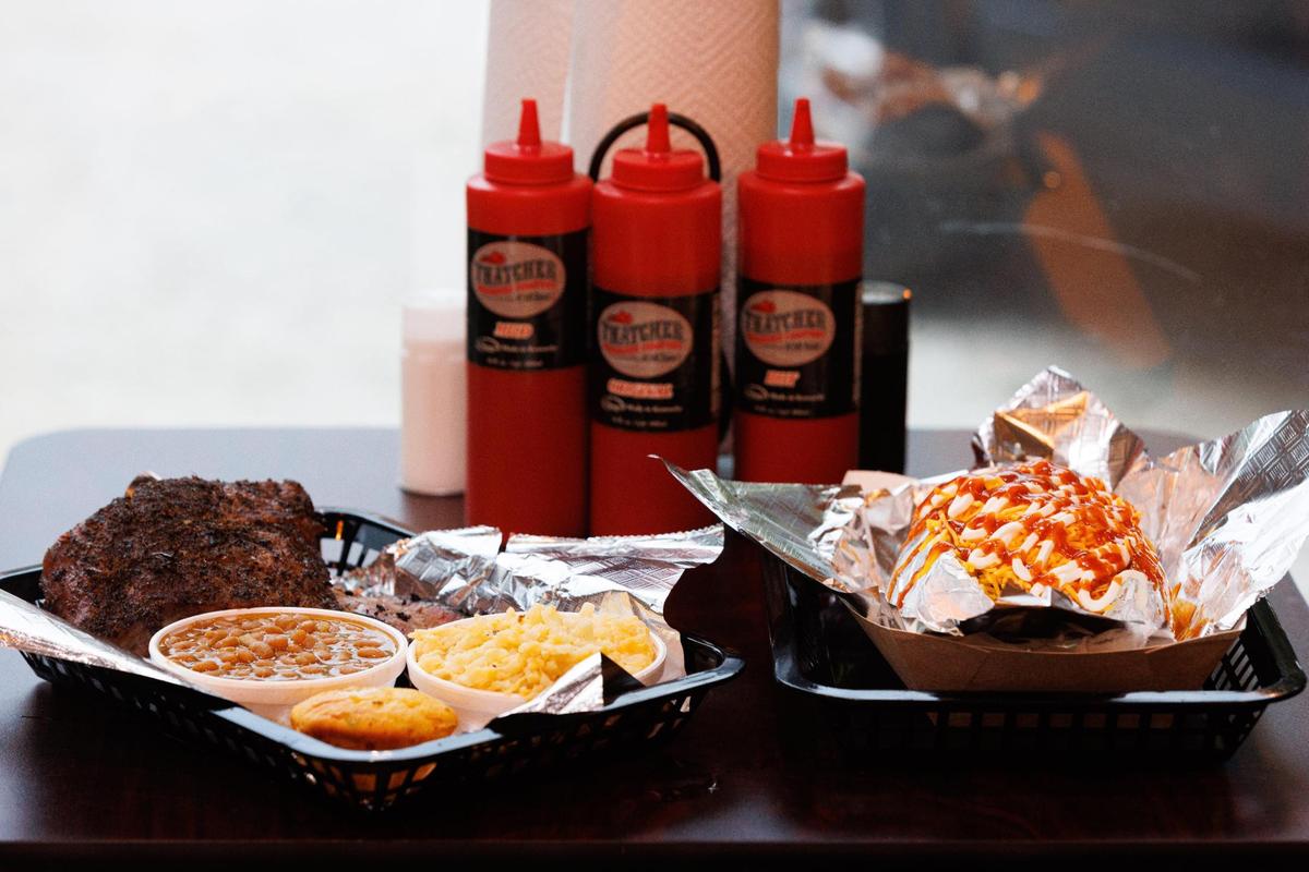 A three meat platter and a barbecue baked potato wait to be eaten on Sunday, June 12, 2022, at Thatcher Barbecue Comapny in Slade, Kentucky.