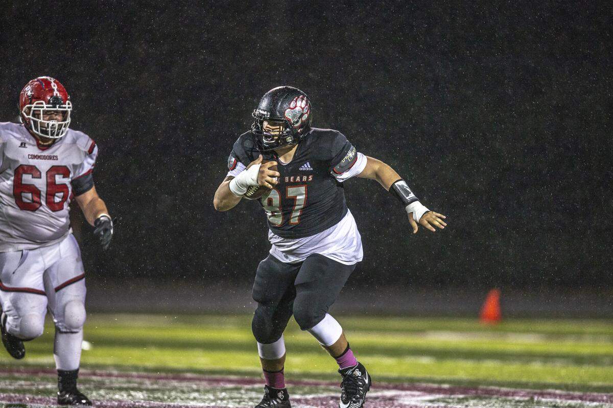 Harlan County’s Elisha Smallwood carries the ball as Perry County’s Ben Gambell chases.