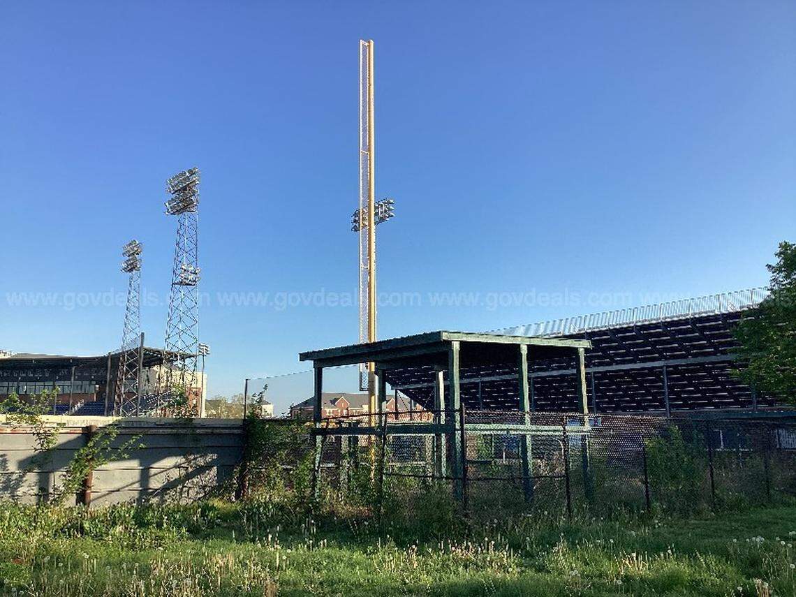 One of the foul poles at Cliff Hagan Stadium, the former home of the Kentucky baseball team, is shown rising above overgrown grass and other plants in the outfield.
