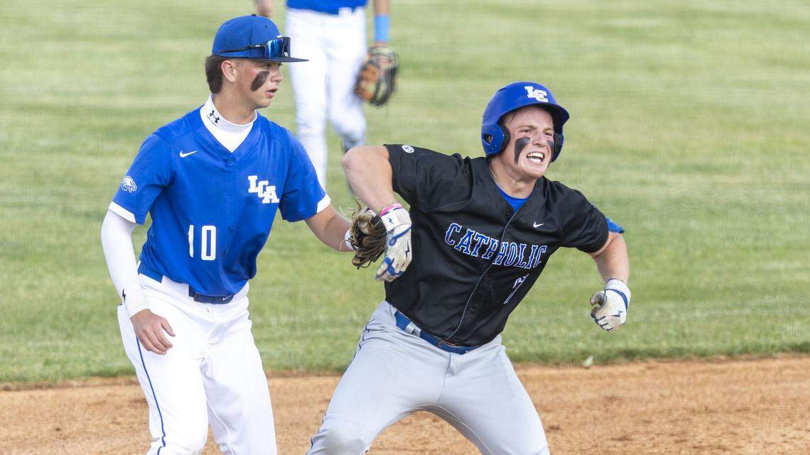 Lexington Catholic's John Crandall (7) celebrates after sliding into third under the tag of Lexington Christian's Jackson Gier (10) for a first-inning triple during a 43rd district high school baseball game, Tuesday, April 28, 2026 at Lexington Christian High School in Lexington, Ky.