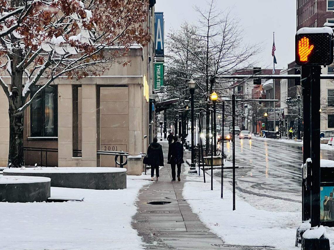 People walk down East Main Street after an overnight storm dropped a few inches of snow in Lexington, Ky. on Dec. 12, 2025.