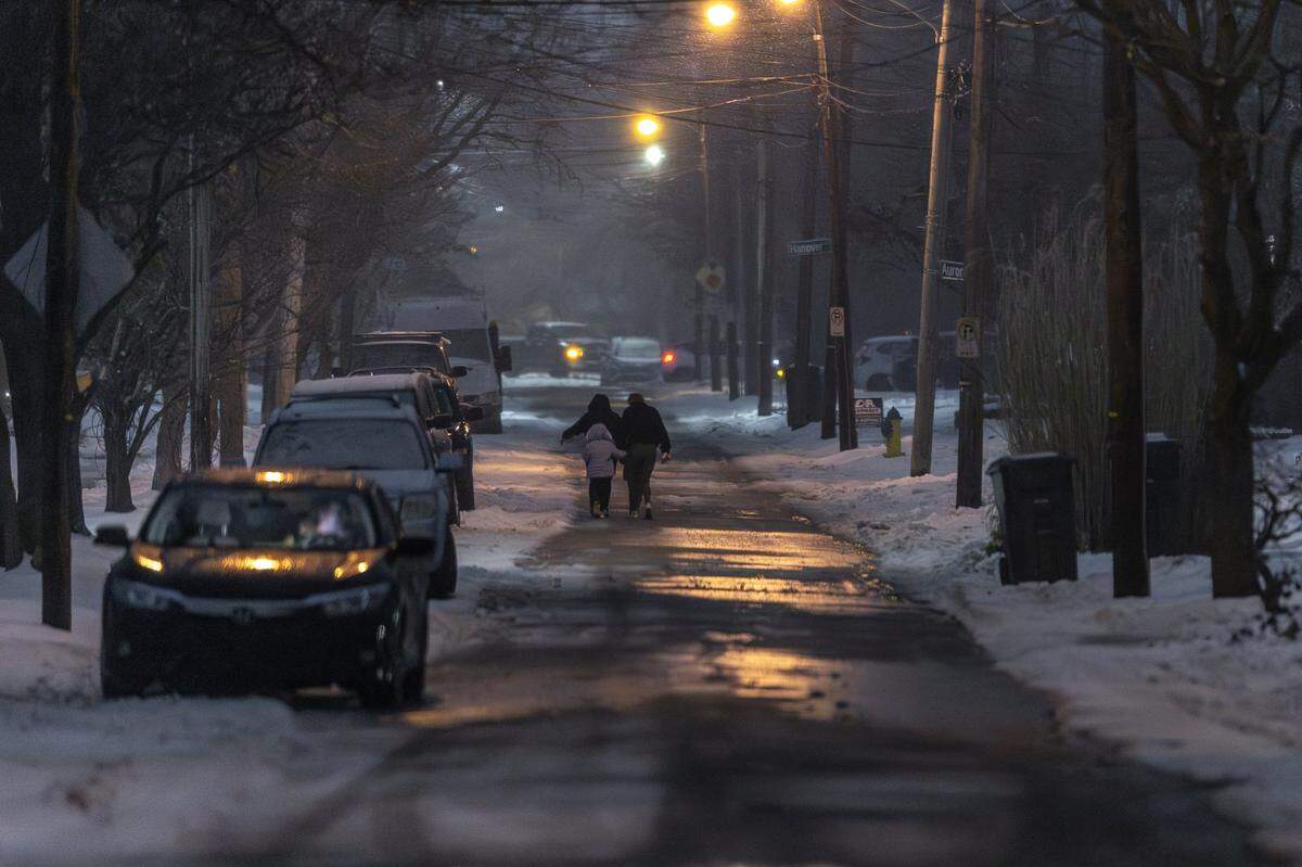 Pedestrians walk along Aurora Avenue during a snowfall in Lexington, Ky., on Tuesday, Feb. 3, 2026.