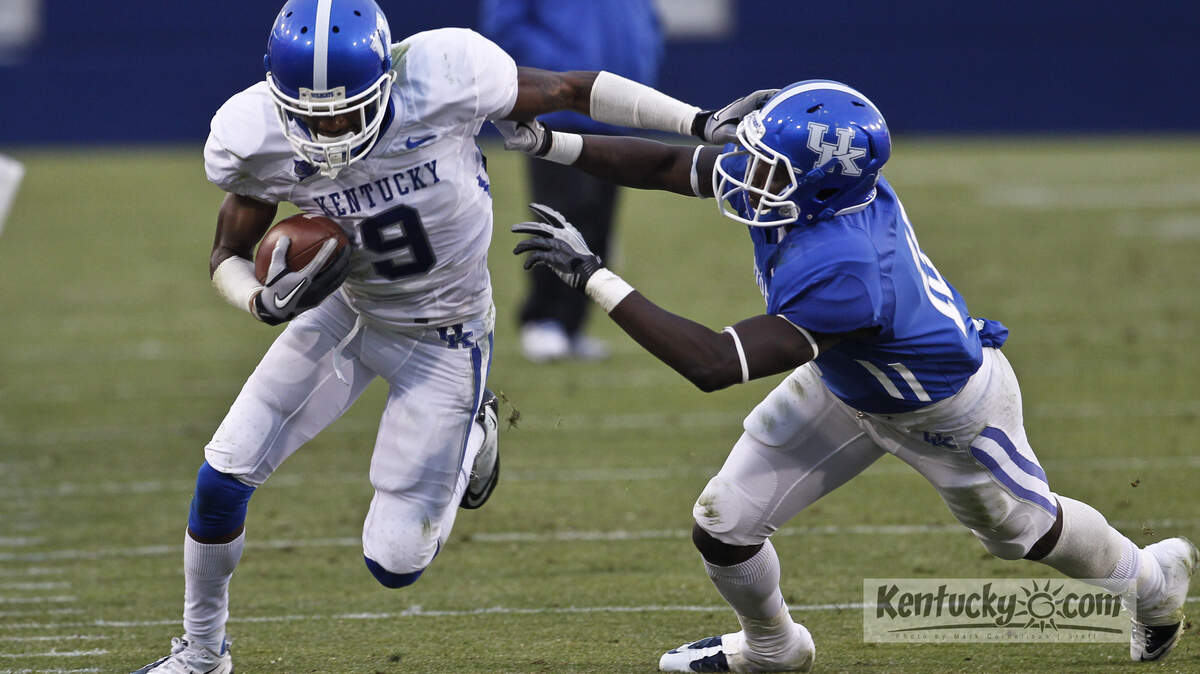 Demarco Robinson stiff armed Marcus Caffey, for extra yardage  during the Blue-White scrimmage  on Saturday  April 21, 2012 in Lexington, Ky. Photo by Mark Cornelison | Staff