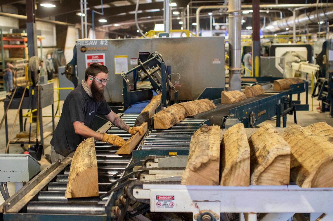 Workers turn white oak logs into staves for 53-gallon bourbon barrels at Robinson Stave Mill in Laurel County on Dec. 13, 2021. The staves are dried for nine-twelve months before they are crafted into barrels.