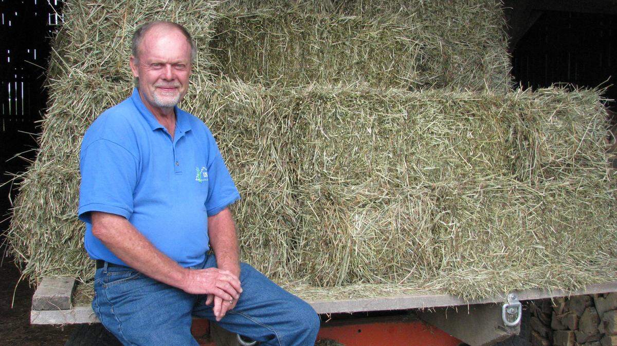 Larry Johnson sat on a wagonload of hay grown on his farm on Troy Pike south of Versailles. The Marion County native worked for 37 years with IBM and Lexmark but now finds "self-satisfaction" in growing hay he sells to area horse farms.     