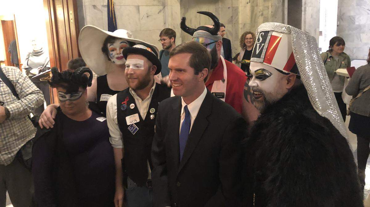 Gov. Andy Beshear poses with representatives from the Kentucky Order of the Sisters of Perpetual Indulgence, an LGBTQ charity group that uses performance art and drag to raise money for charity.