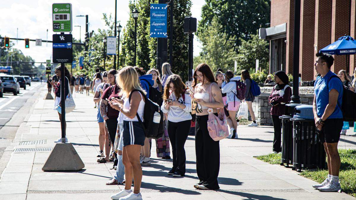 Students on their cell phones wait for LexTran outside the Gatton Student Center during UK's first day of the fall semester on August 25, 2025, in Lexington, Ky.
