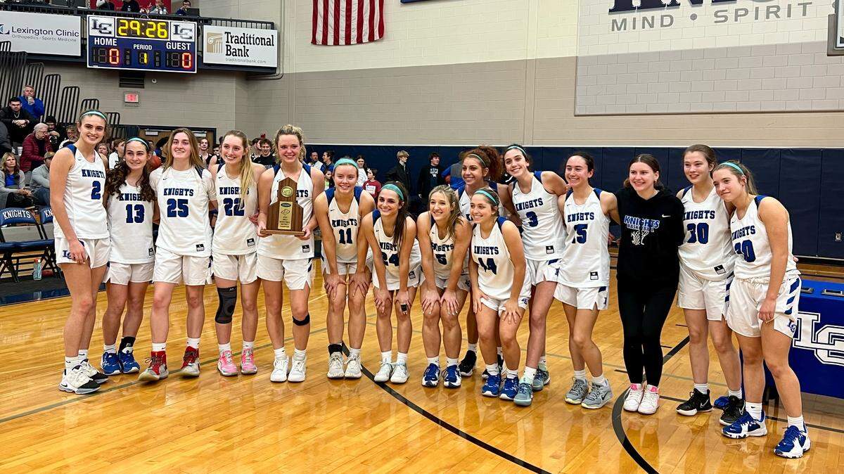 The Lexington Catholic Knights pose with their trophy after defeating Tates Creek to win the 43rd District Tournament on their home court on Friday night.