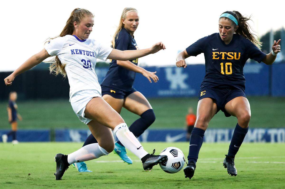 Jordyn Rhodes dribbles the ball past a pair of East Tennessee State players during an August exhibition match between the Buccaneers and Wildcats. Rhodes has scored eight goals in eight games for the Wildcats this season.