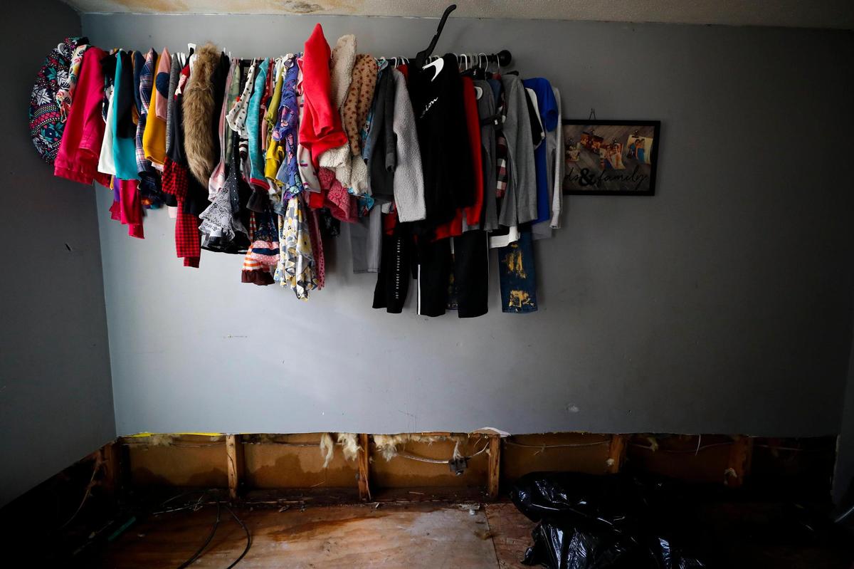 Clothing and a framed picture hang on the wall in a room at the Smith household in Sidney, Ky., Thursday, Jan. 13, 2022. The trailer home was damaged when Big Creek rose nearly 30 feet in minutes on Jan. 1.
