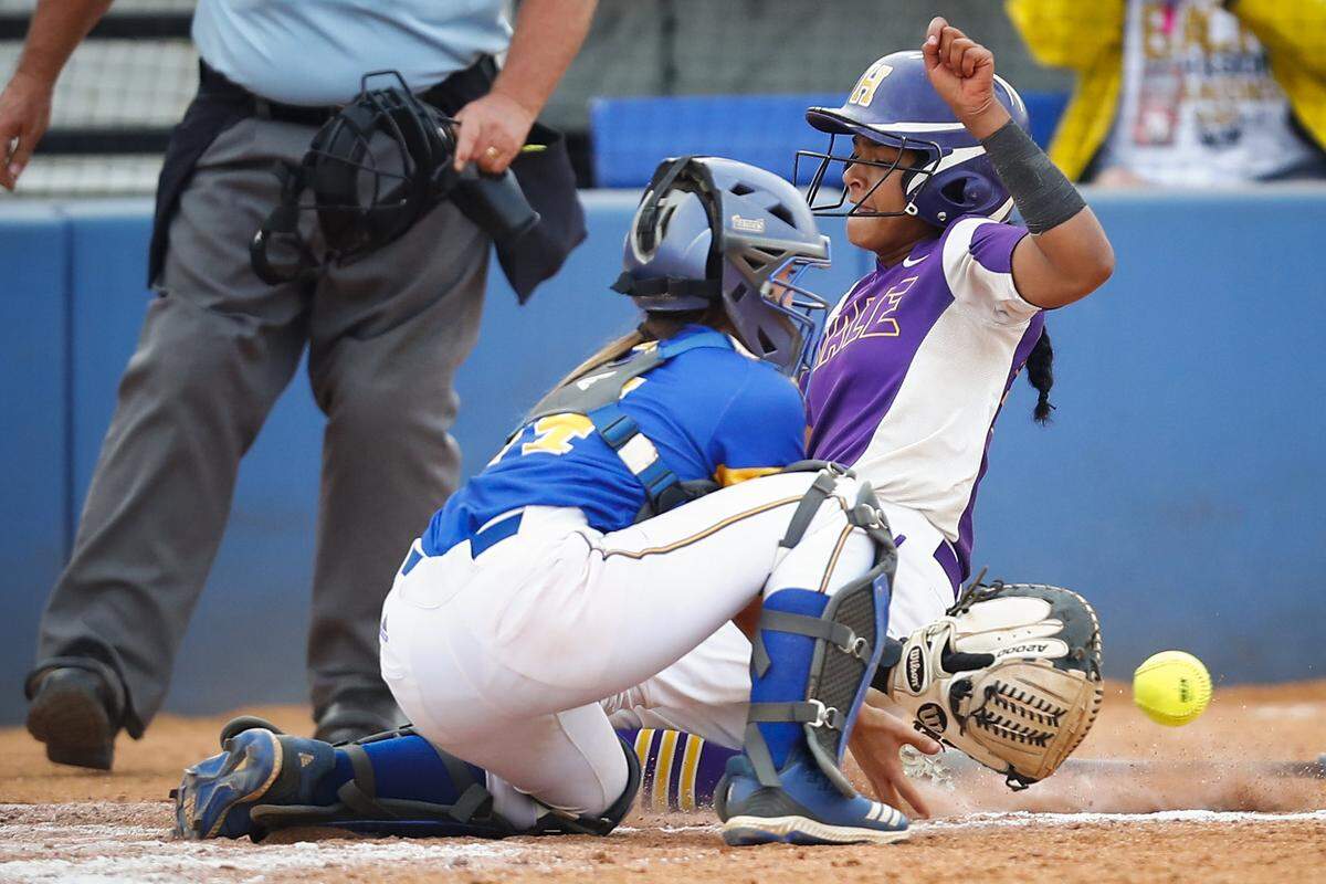 Male’s Jaelyn Sanders (24) slides into home past Warren East’s Harley Stringfield (14) during the KHSAA State Softball Tournament championship at John Cropp Stadium in Lexington, Ky., Saturday, June 15, 2019. Male beat Warren East 6-1. 