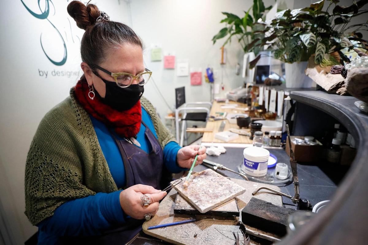 Rachel SavanŽ, of Lexington, Ky., owner and jewelry designer at SavanŽ Silver shows creates ÔcompassionÕ mask pin with an aventurine gemstone at SavanŽ Silver in Lexington, Thursday, Dec. 17, 2020.