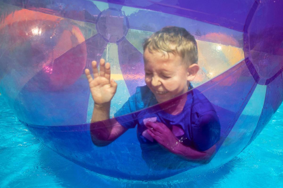 Wyatt Thacker, 7, of Pikeville rolls around inside of a giant ball in a pool of water during Hillbilly Days in downtown Pikeville, Ky., on Saturday, April 23, 2022. This marked the first time the event was held since 2019.