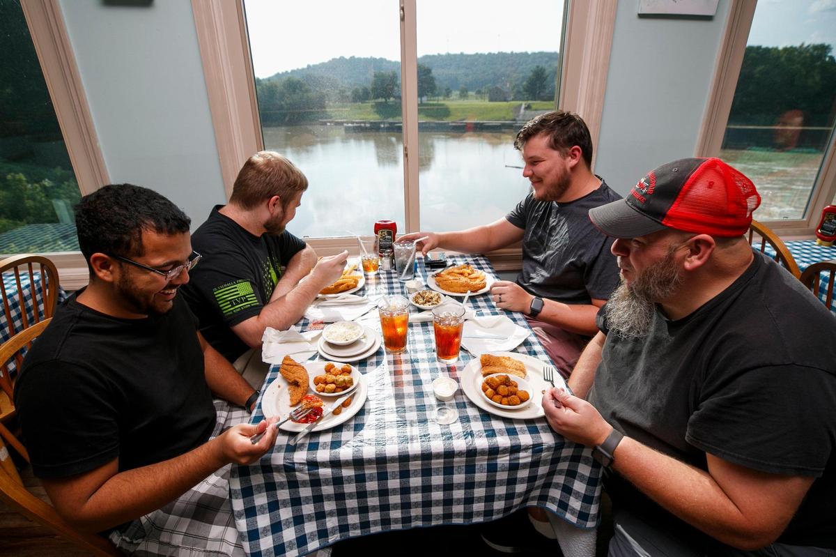 Khalil Bishop, clockwise from lower left, Chris Powell, Lyle Turner, all of Frankfort, Ky., and Owen Bennett, of Owenton, Ky., joke while eating dinner at Jim’s Seafood in Frankfort, Ky., Thursday, Aug. 26, 2021.