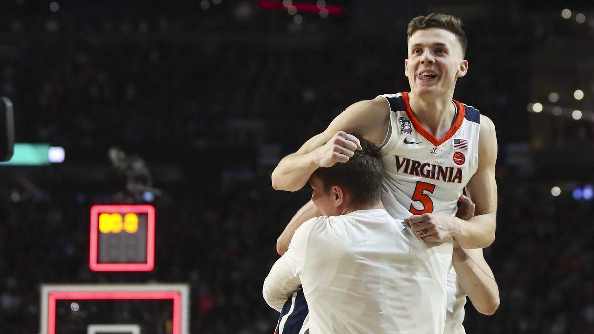 Virginia’s Kyle Guy (5) is lifted off the floor by teammates after he sunk three free throws to win the game for Virginia against Auburn in a semifinal of the NCAA Tournament Final Four on Saturday, April 6, 2019, at U.S. Bank Stadium in Minneapolis. Virginia advanced, 63-62.