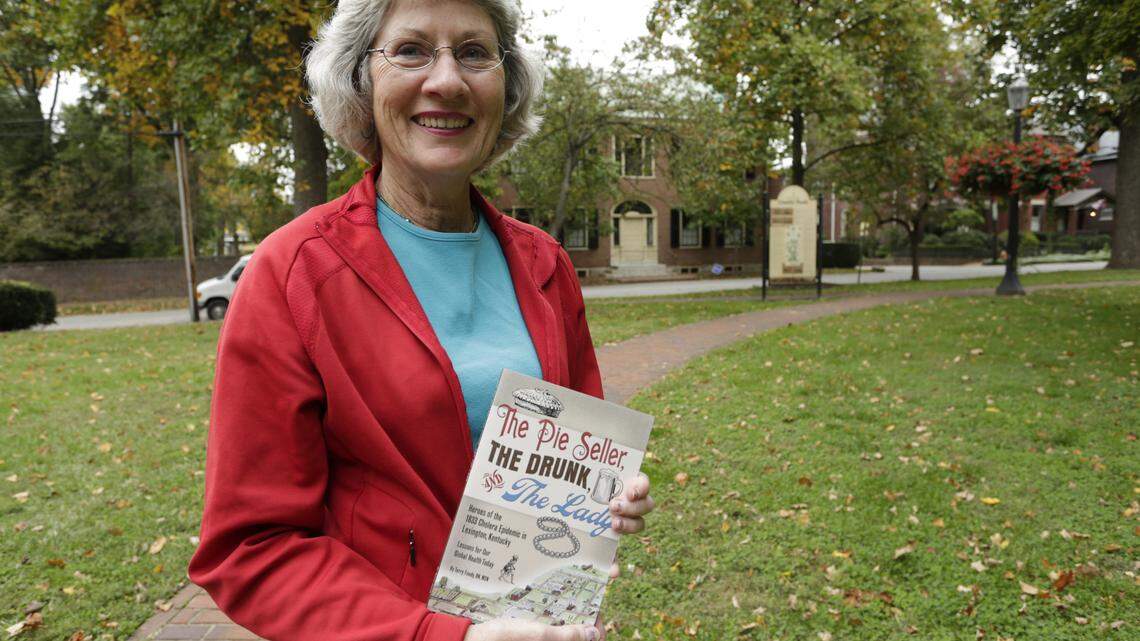 Terry Foody, at Gratz Park with the Gratz House behind her, with her new book, The Pie Seller, The Drunk and the Lady, about Lexington's 1833 cholera epidemic.  
