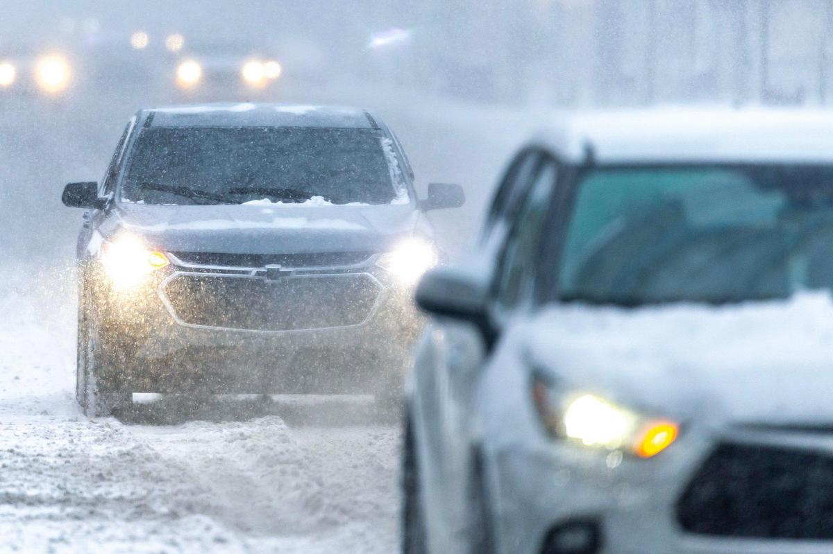 Vehicles drive through snow in downtown Lexington,Ky., on Sunday, Jan. 5, 2025.