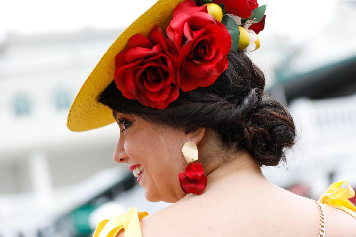 Nicolette Rockwell wears rose petal inspired earrings she purchased from Etsy at Churchill Downs in Louisville, Ky., Saturday, May 7, 2022. The back of her fascinator featured a Secretariat pin with roses. She said her hair was inspired by a look she found on Pinterest and she stayed frugal and purchased her entire outfit for under $200.